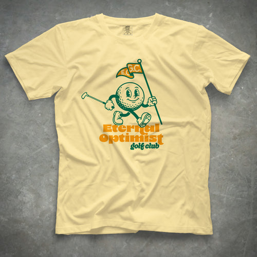 Yellow t-shirt with a 1950s-inspired golf ball cartoon that has legs and arms. He is carrying a putter and a flagstick that has "E.O.G.C." on the flag. Below him are the words 'Eternal Optimist Golf Club'.