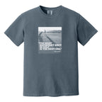 Muted blue t-shirt that has an image of a golfer with a quote from Ben Hogan: "The most important shot in golf is the next one."