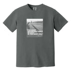 Dark gray t-shirt that has an image of a golfer with a quote from Ben Hogan: "The most important shot in golf is the next one."