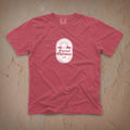 Dark pink t-shirt with a white Eternal Optimist Golf Club logo on a beige textured background.